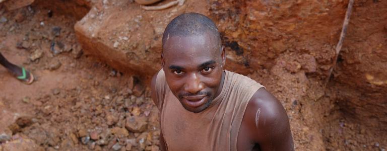 A man looks up from an open mine